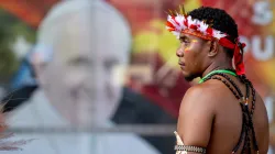 A man stands in front of a poster of Pope Francis outside APEC Haus in Port Moresby, Papua New Guinea, to welcome the Roman pontiff, Sept. 7, 2024. / Credit: Daniel Ibáñez/CNA