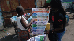 An official of Caritas Congo taking a local through COVID-19 information. / Caritas Congo