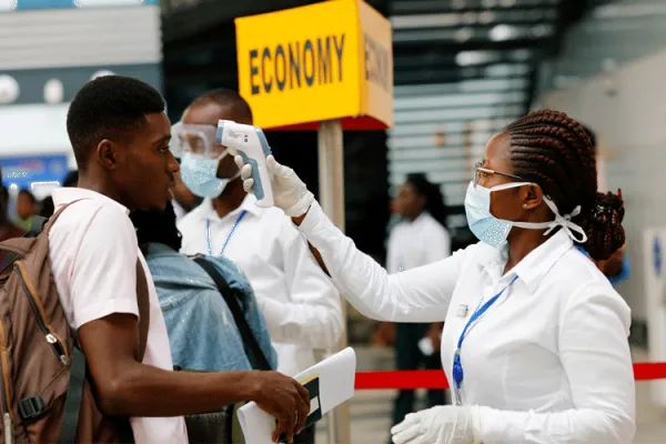 Health Personnel checks the temperature of a traveller in coronavirus screening at Kotoka International Airport, Accra, Ghana.