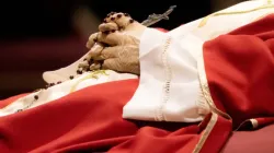 Rosary beads entwined in the hands of the late Pope Emeritus Benedict XVI as his body lies in state on Jan. 3, 2023, in St. Peter's Basilica. | Daniel Ibañez/CNA