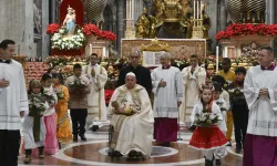 Pope Francis carries the statue of the Child Jesus to place in the Nativity scene inside St. Peter's Basilica at the end of Mass on Christmas Eve, Dec. 24, 2024, surrounded by children dressed in traditional clothing from their countries. / Credit: Vatican Media