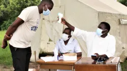 Nurses check on a man's temperature as he walks into Muvonde Mission Hospital / Catholic Church news in Zimbabwe