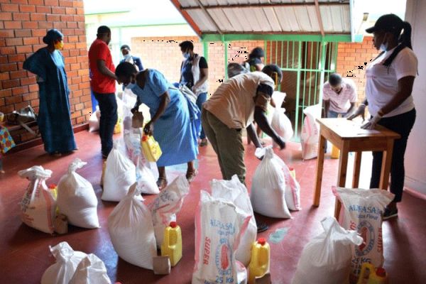 Staff of the Jesuit Urumuri Centre (JUC) prepare food items for vulnerable families in Rukiri II cell, a village in Remera sector, Rwanda. / Jesuit Urumuri Centre (JUC).