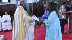 Fr. Bernard Hona Tonye hands certificates to couples with at least 15 years in marriage. Credit: Aïcha Marianne Kola