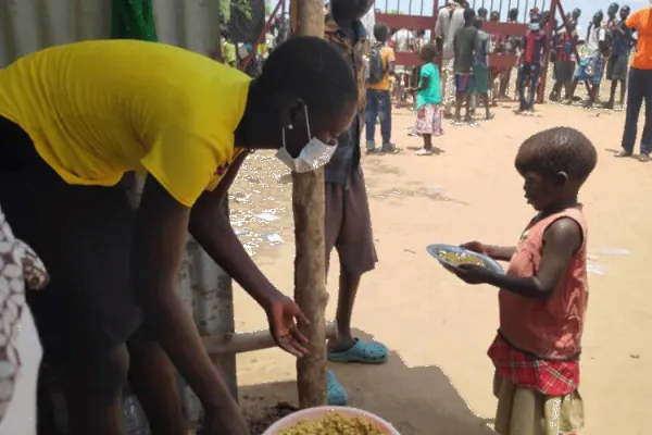 A volunteer serves food to children at Don Bosco Gumbo IDP camp, Juba. / Salesians of Don Bosco