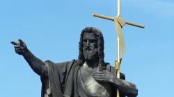 Statue of St. John the Baptist with golden cross, Charles Bridge, Prague, Czech Republic. / Credit: Oldrich Barak/Shutterstock