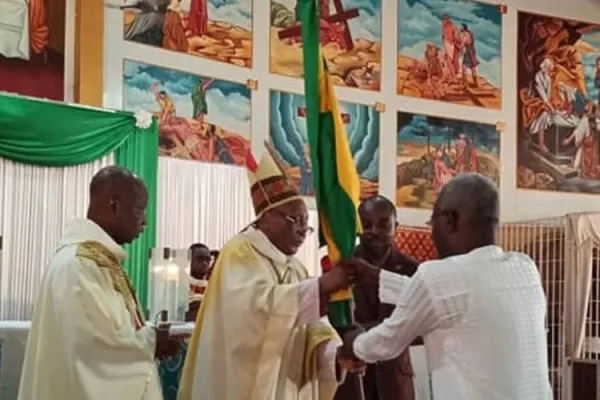Archbishop Emeritus of Lome, Philippe Fanoko Kpodzro hands over the Togolese flag to Messan Agbeyomé Kodjo, one of the presidential candidates on February 1, 2020. / Togo Breaking News