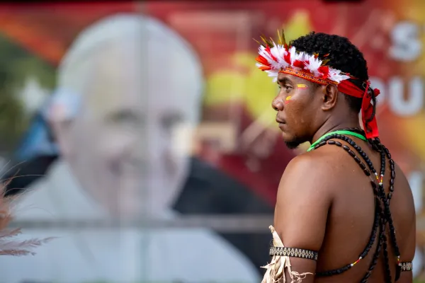 A man stands in front of a poster of Pope Francis outside APEC Haus in Port Moresby, Papua New Guinea, to welcome the Roman pontiff, Sept. 7, 2024. / Credit: Daniel Ibáñez/CNA