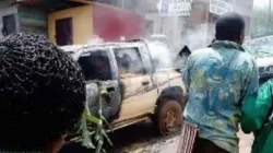 Civilians walk past burning vehicles in Elak town, Northwest Cameroon Credit: Denis Hurley Peace Institute