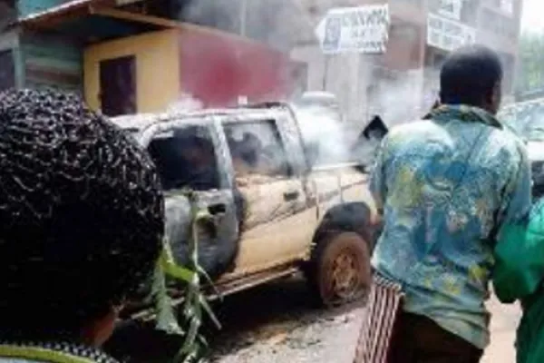 Civilians walk past burning vehicles in Elak town, Northwest Cameroon Credit: Denis Hurley Peace Institute