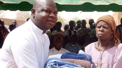 A well-wisher hands over clothing to a displaced woman in Burkina Faso. / Caritas Burkina Faso