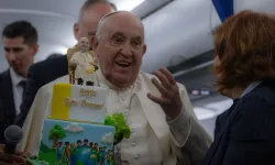 Pope Francis is presented with a birthday cake aboard the papal plane on the return from his trip to Corsica on Sunday, Dec. 15, 2024. / Credit: Daniel Ibáñez/CNA