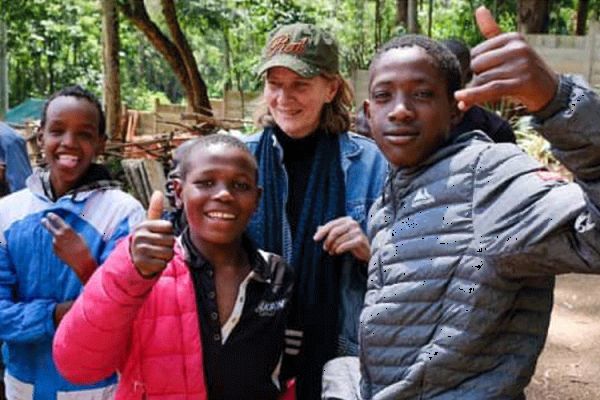 Street children that are part of the Nairobi-based Alfajiri Street Kids Art pose for a photo with the founder of the facility, Australian-born Lenore Boyd (at the back) / Joost Bastmeijer for Beyond the Orphanage