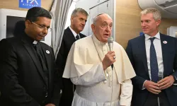 Pope Francis addresses journalists aboard the papal plane heading to Mongolia, with Cardinal-elect George Jacob Koovakad at left, on Aug. 31, 2023. / Credit: Alberto PIZZOLI/POOL/AFP