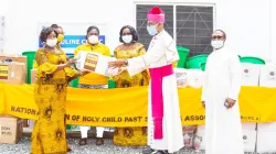 Archbishop Palmer-Buckle, Vice President of the Ghana Catholic Bishops’ Conference receiving a donation from  Mrs. Asor Anyimadu-Antwi, on behalf of the  National Union of Past Students of Holy Child School. / Global Newswatch Media