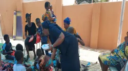 Sr. Olivia Umoh, DC, Director of Safe-Child Advocacy (SCA), a Humanitarian Organisation owned by the Archdiocese of Kumasi, sharing food to Children with disability and their mothers at a recent party for the vulnerable. / SCA.