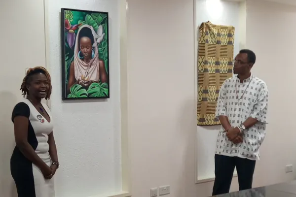Fridah Ijai, a Kenyan realism artist, describes painting in which she brings out the difference between the Even of the Old Testament and Mary, the Mother of Jesus who she describes as the 'New Eve'. The President of the Jesuits Conference of Africa and Madagascar, Fr. Agbonkhianmeghe Orobator looks on. Credit: ACI Africa