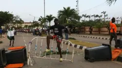 A demonstrator sits on a barricade blocking a road near the Lagos State House, despite a round-the-clock curfew imposed by the authorities on the Nigerian state of Lagos in response to protests against alleged police brutality, Nigeria. / Reuters