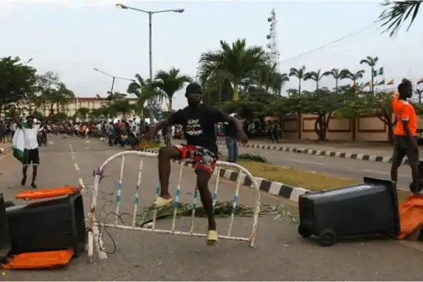 A demonstrator sits on a barricade blocking a road near the Lagos State House, despite a round-the-clock curfew imposed by the authorities on the Nigerian state of Lagos in response to protests against alleged police brutality, Nigeria. / Reuters