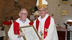 Archbishop Stephen Brislin (right) presents Msgr Barney McAleer (left) with a framed certificate in gratitude for his work in Southern Africa.