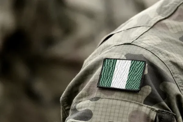 The flag of Nigeria on a military uniform. Bumble Dee/Shutterstock.