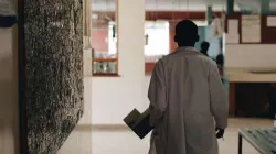 Doctor in white medical gown walking through the hospital lobby in village in Africa. Via Shutterstock