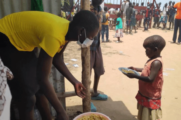 A volunteer serves food to children at Don Bosco Gumbo IDP camp, Juba. / Salesians of Don Bosco