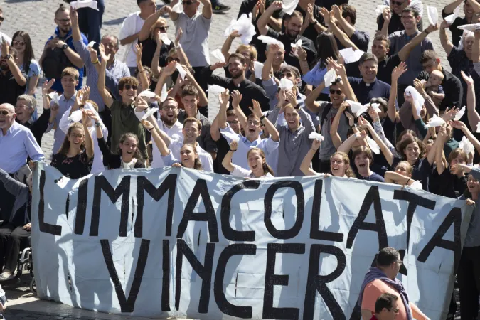 Members of the Casa di Maria (“House of Mary”) community wave at Pope Francis as they hold a banner that says in Italian, “The Immaculate Conception will triumph.” Pope Francis greeted the community, which is celebrating three priestly ordinations, at the end of his Angelus on Sept. 15, 2024.